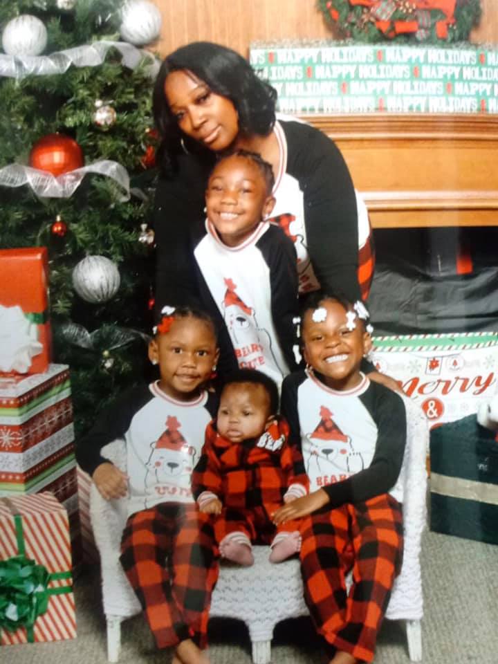 Mother with her four children, smiling in a family portrait